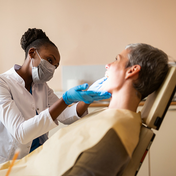 doctor looking at patients mouth in dental chair