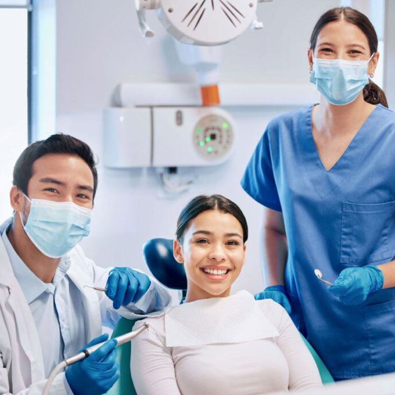 patient in dental chair with doctors on either side