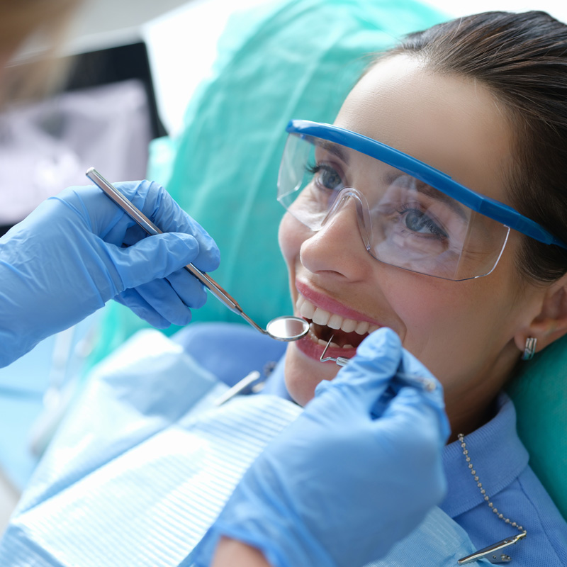 woman in dental chair getting teeth cleaned
