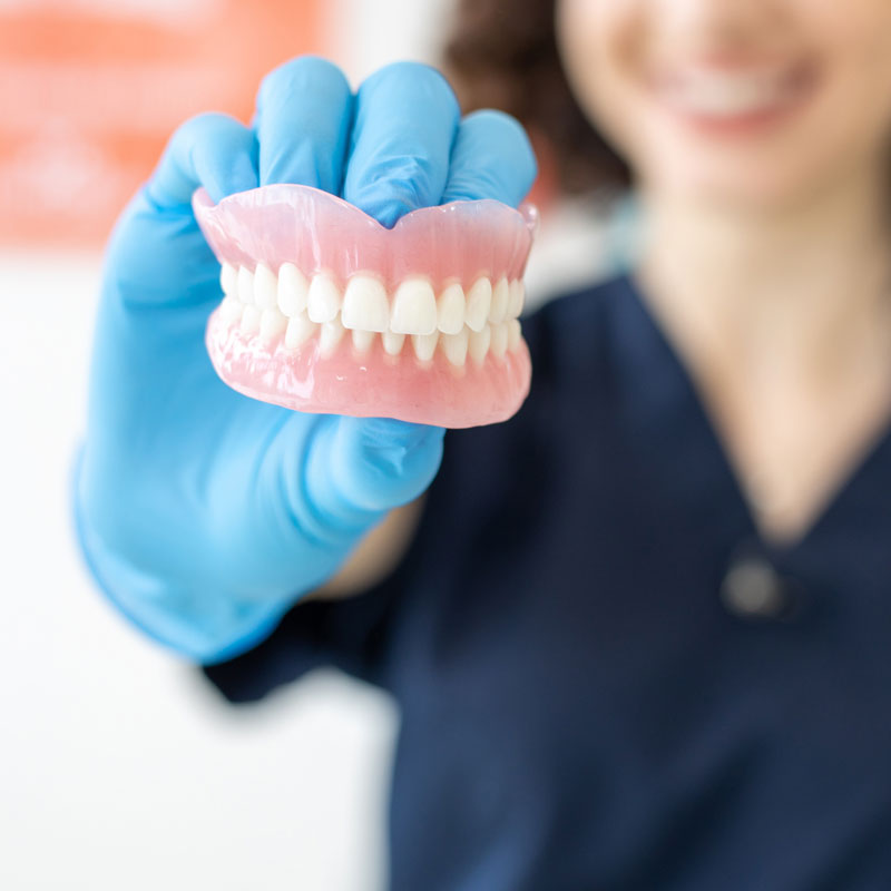 doctor holding dentures