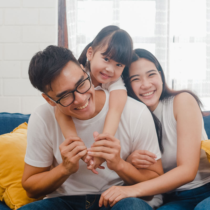 family smiling sitting on a couch