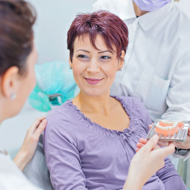 Woman at the dentist looking at dentures